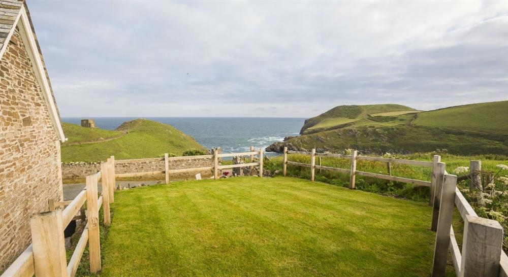 The garden area and view of Doyden Castle at Doyden Stable Cottage in Port Quin, Cornwall