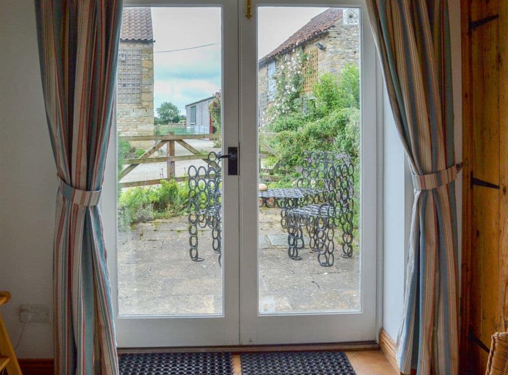 French doors from living area to patio seating area at Dragonfly Cottage in Brompton by Sawdon, North Yorkshire