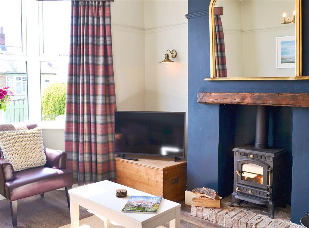 Cosy living room with wood burner at Driftwood Cottage in Seahouses, Northumberland