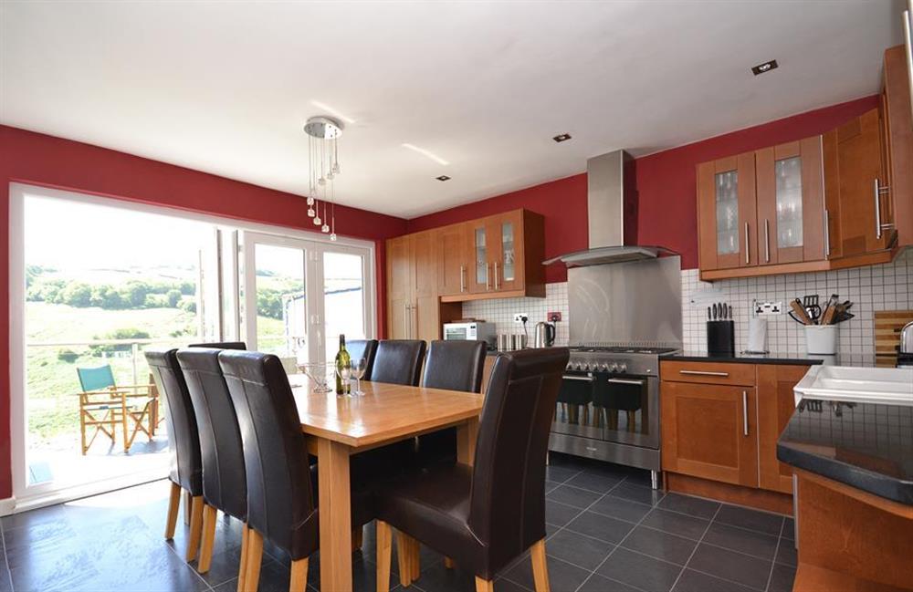 The modern kitchen diner with fully folding patio doors leading out to the top balcony at Driftwood, Dartmouth