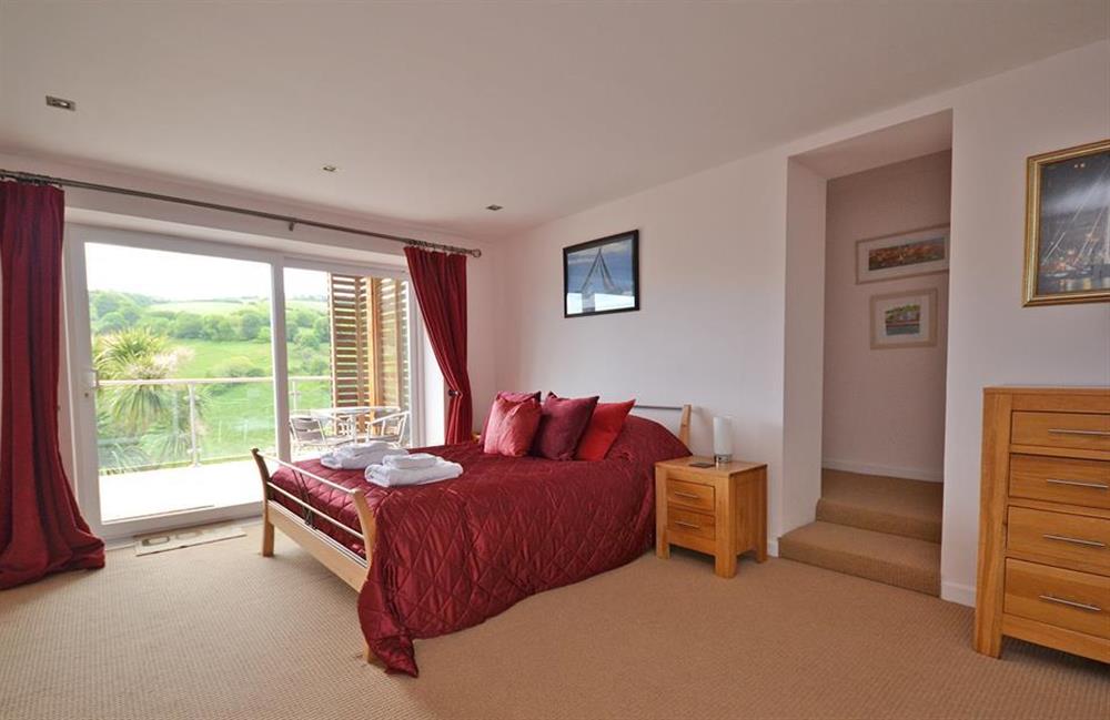The spacious master bedroom with patio doors leading out to the decked terrace at Driftwood, Dartmouth