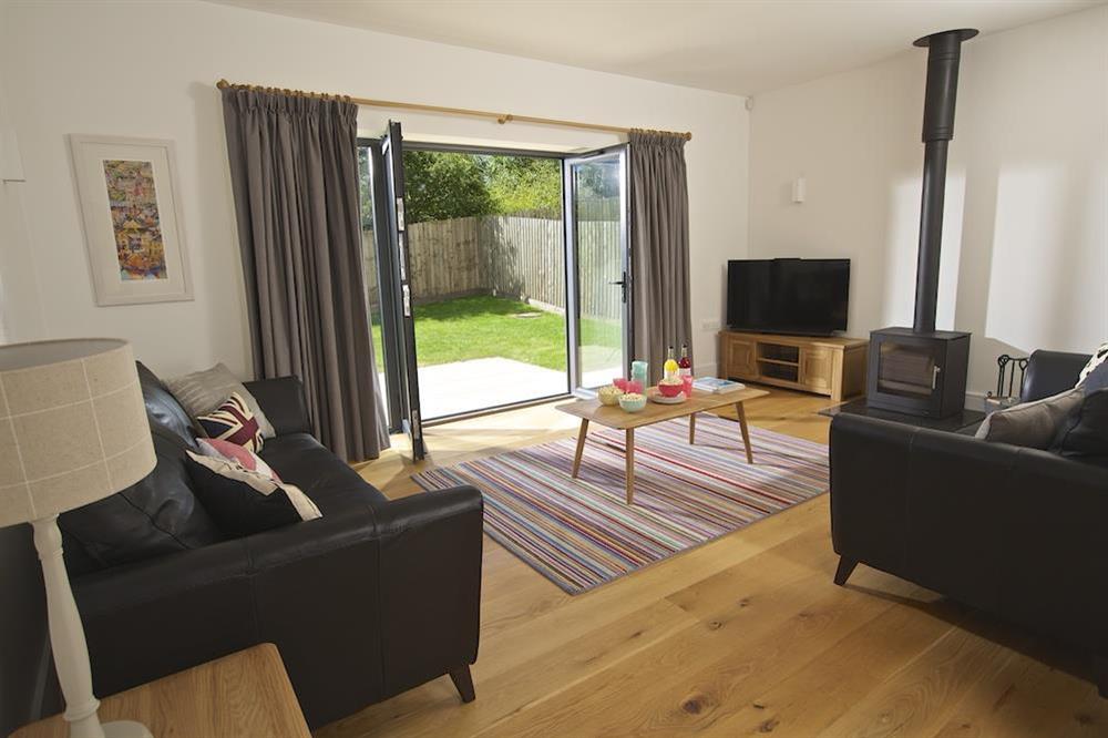 Ground floor family room with wood burning stove and doors out to the garden at Driftwood in , Salcombe