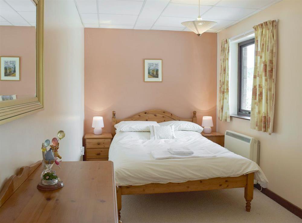 Relaxing double bed within triple sleep bedroom at Dunns Meadow in Llanrhidian, near Swansea, West Glamorgan