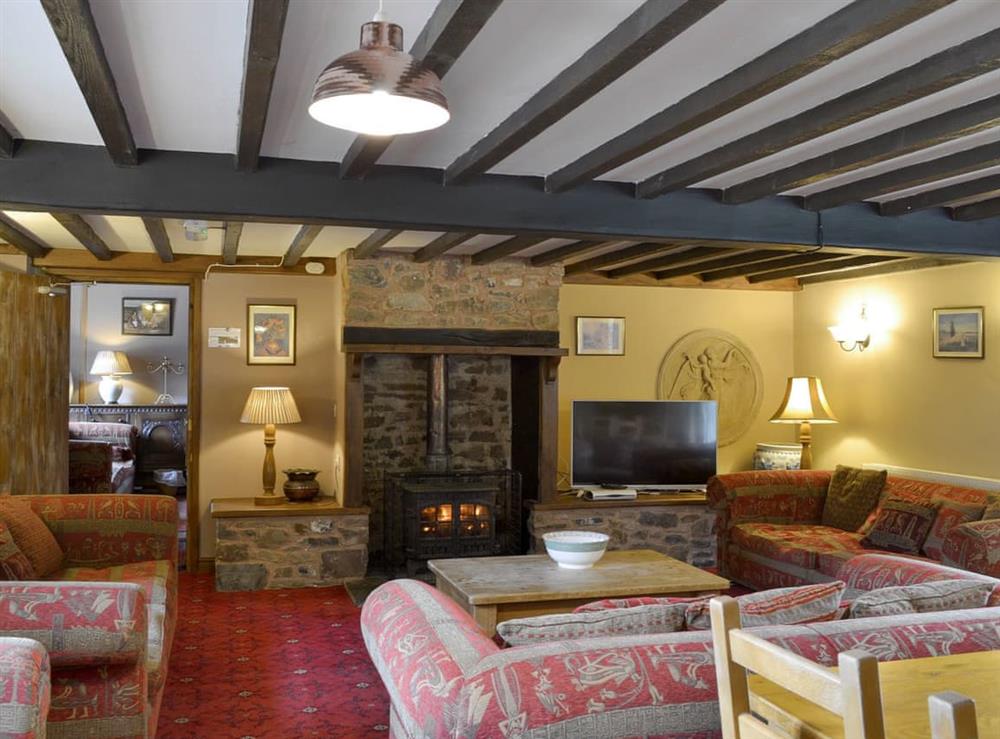 Spacious living and dining room with wood burner at Duvale Barn, 