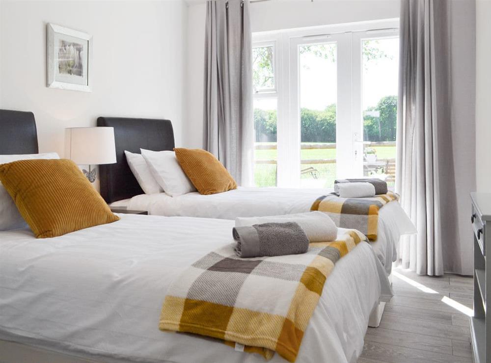 Light and airy twin bedroom with French doors to patio at The Duck House, 