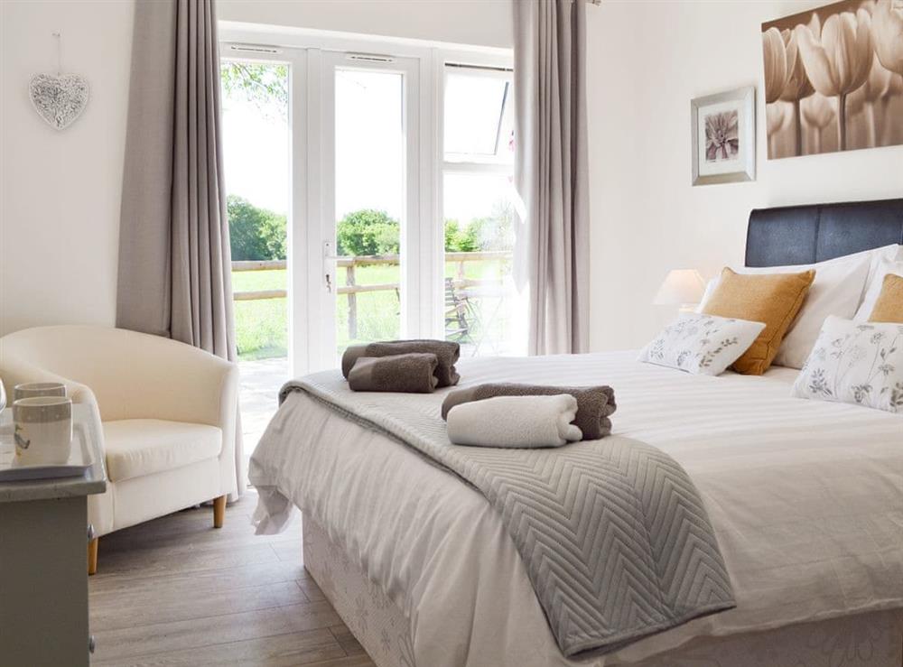 Relaxing en-suite double bedroom with French doors to patio at The Duck House, 