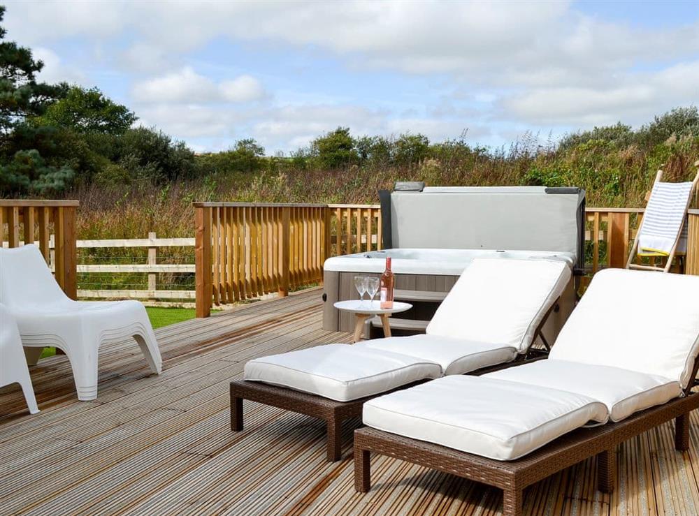 Extended decking areas with loungers and hot tub (photo 2) at Eagle Owl Lodge in Winnard’s Perch, near St Columb Major, Cornwall