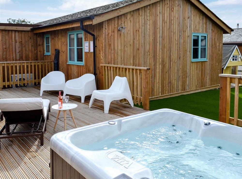 Extended decking areas with loungers and hot tub at Eagle Owl Lodge in Winnard’s Perch, near St Columb Major, Cornwall
