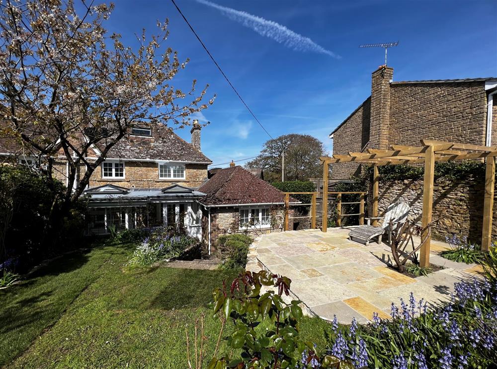 The patio and pergola area provides a relaxing space for sunny days