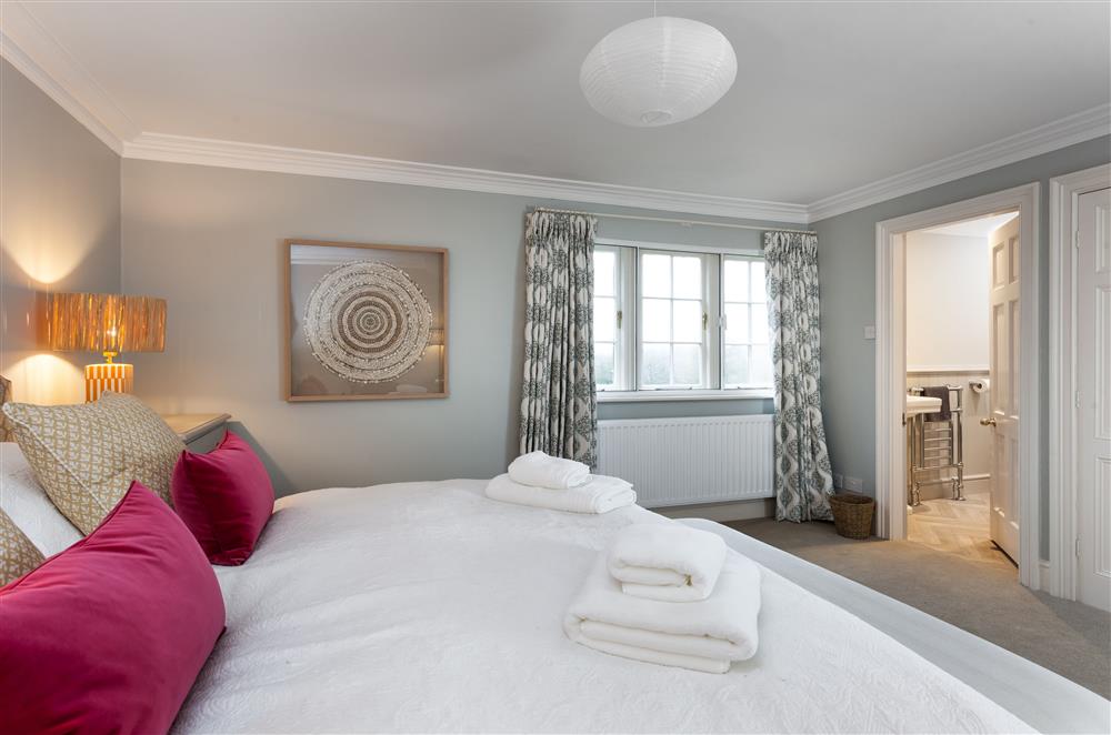 Bedroom one with a 6’ super-king size bed and en-suite bathroom at East House, Arley