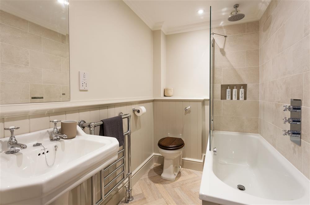 En-suite bathroom to bedroom one with a bath and over-head shower at East House, Arley