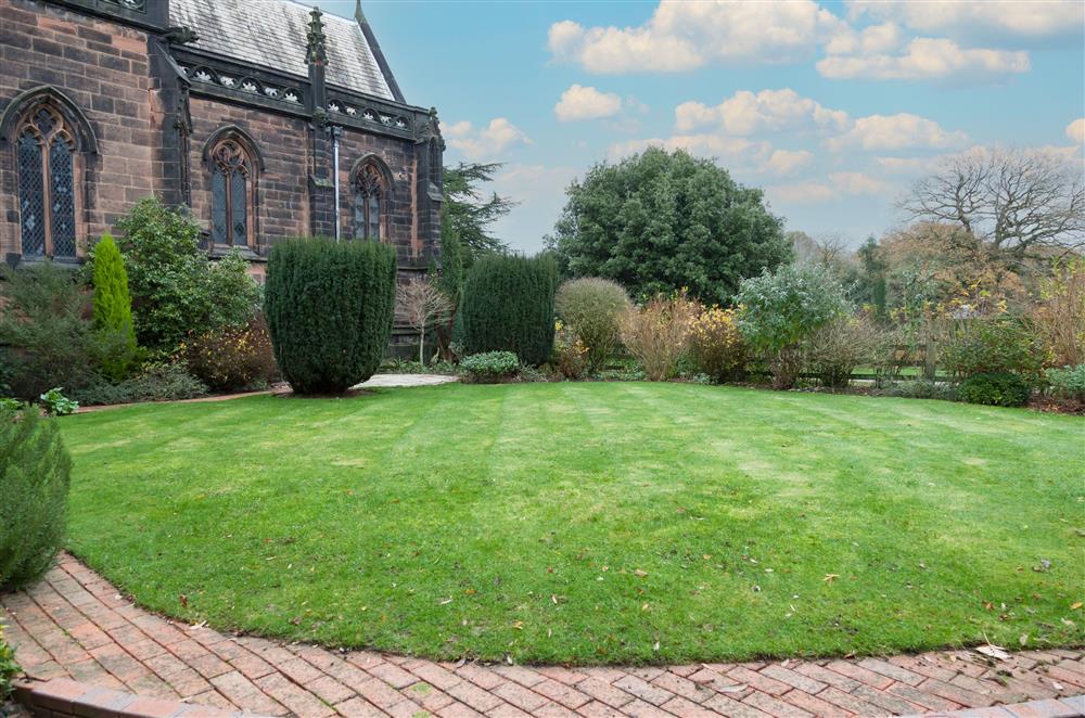Enclosed lawned garden with views of the chapel and estate at East House, Arley