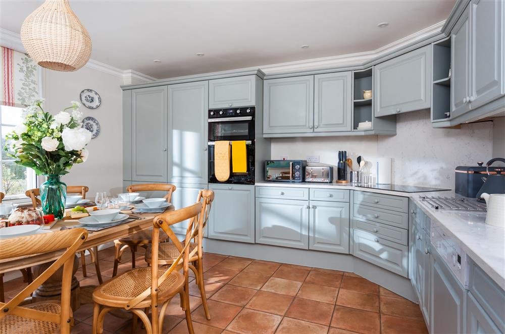 Fully-fitted modern kitchen with breakfast table seating eight guests at East House, Arley