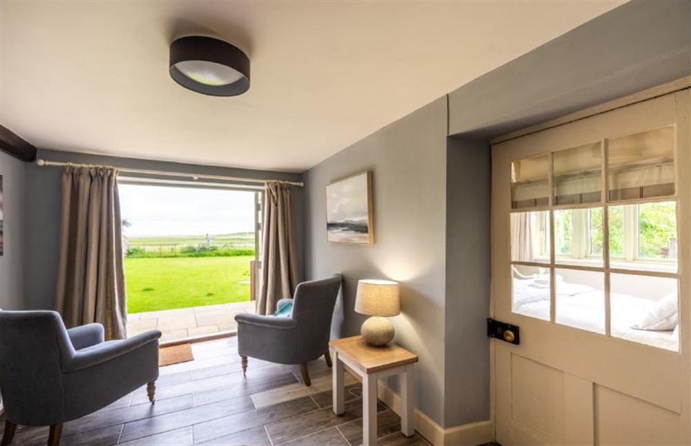 Ground floor: Seating area overlooking the front garden to the marsh and sea beyond at Eastgate Cottage, Salthouse near Holt