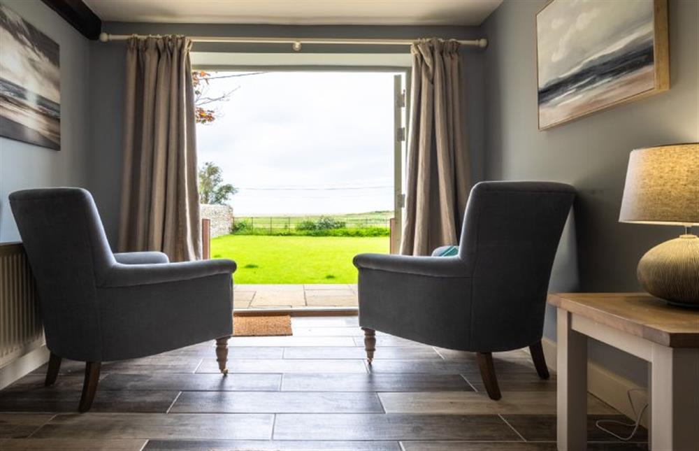 Ground floor: Seating area overlooking the garden and marsh/sea beyond at Eastgate Cottage, Salthouse near Holt