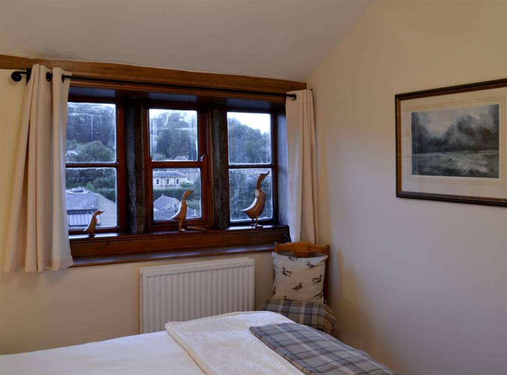 Double bedroom with mullioned windows at Eider Cottage in Holmfirth, West Yorkshire