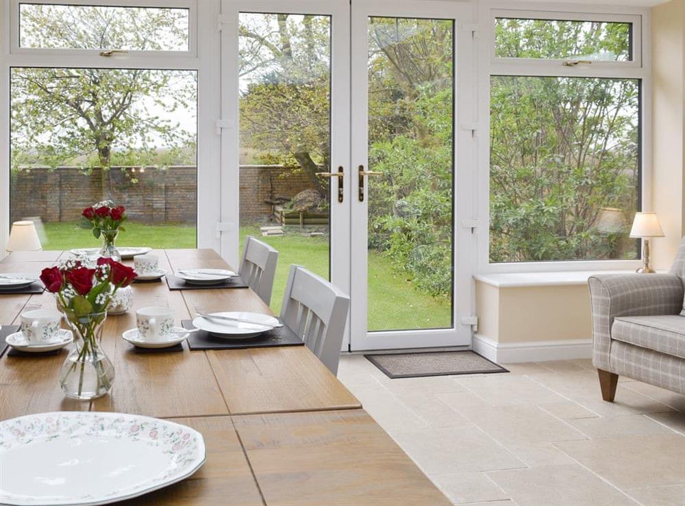 Spacious and contemporary dining room with French doors to garden at The Gatehouse, 