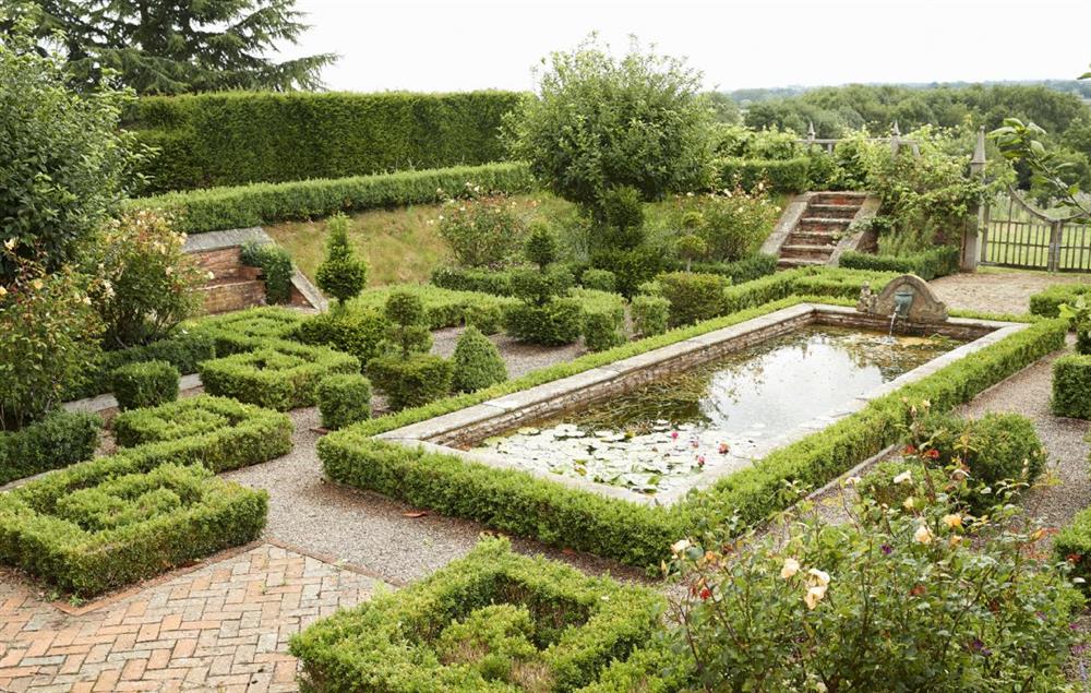 The sunken garden has an ornamental pond surrounded by beds of tulips, alliums and roses at Elinor Fettiplace, Pauntley
