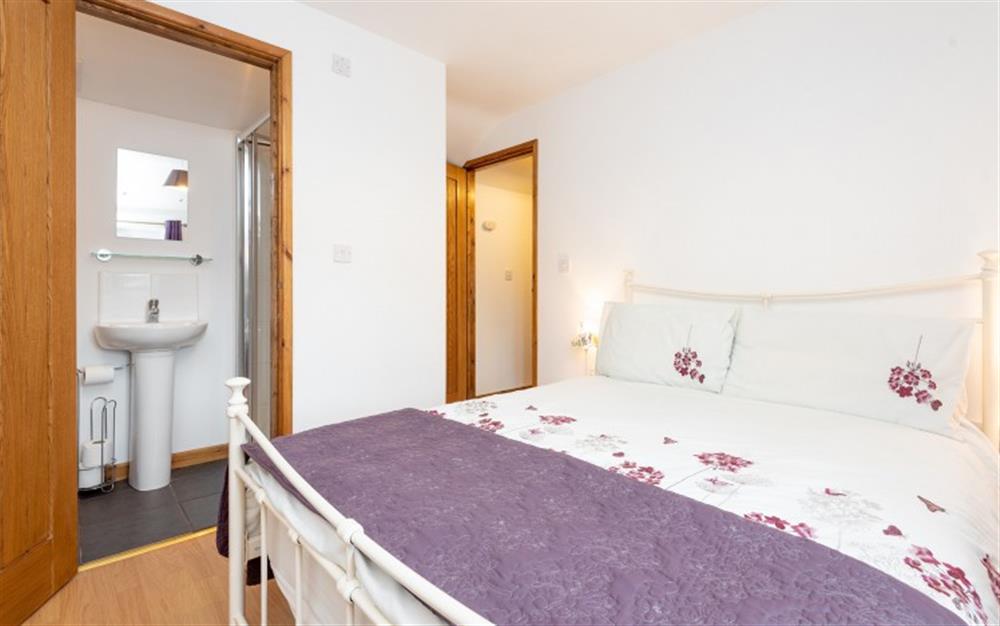Double bed with enusite shower at Elm Cottage in Colyford