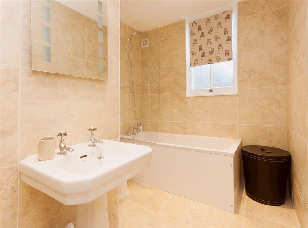 A large fully tiled family bathroom with over bath shower at Elm Grove in Dartmouth, Devon