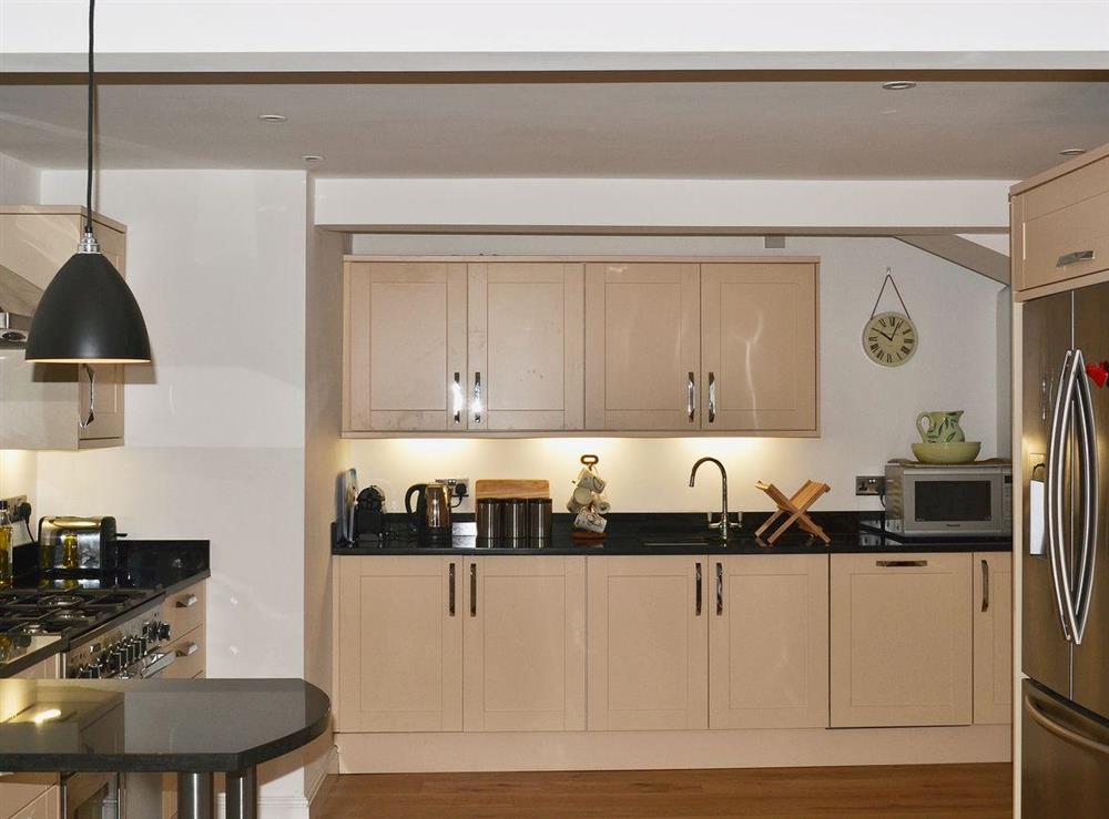 Granite worktops and a stylish breakfast bar complete the modern kitchen at Elm Grove in Dartmouth, Devon