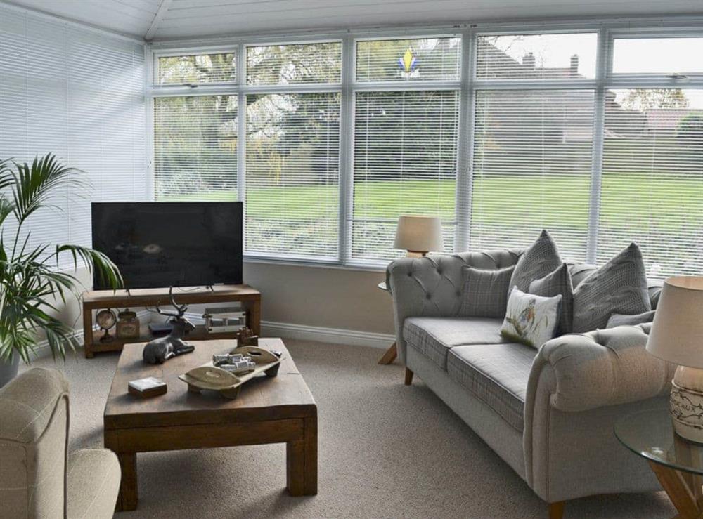 Tastefully furnished living room with French doors leading to the patio at Elm Tree Cottage at Cottage Farm in Foxholes, near Scarborough, North Yorkshire