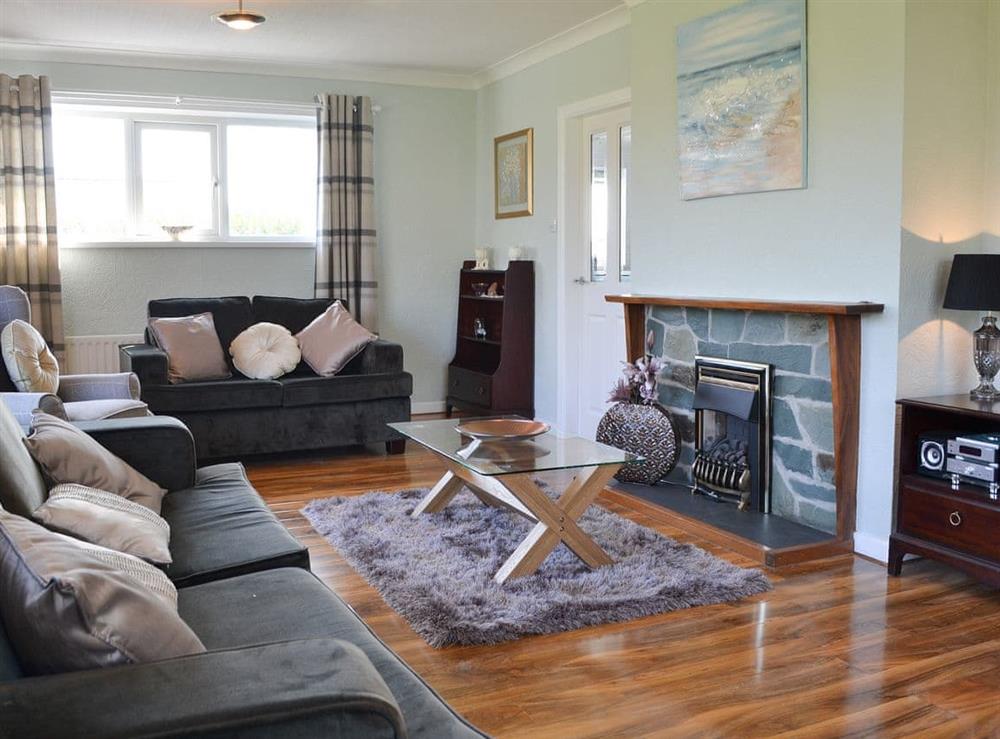 Spacious living room with wooden floor at Encil-Y-Mor in Criccieth, near Porthmadog, Gwynedd, Wales