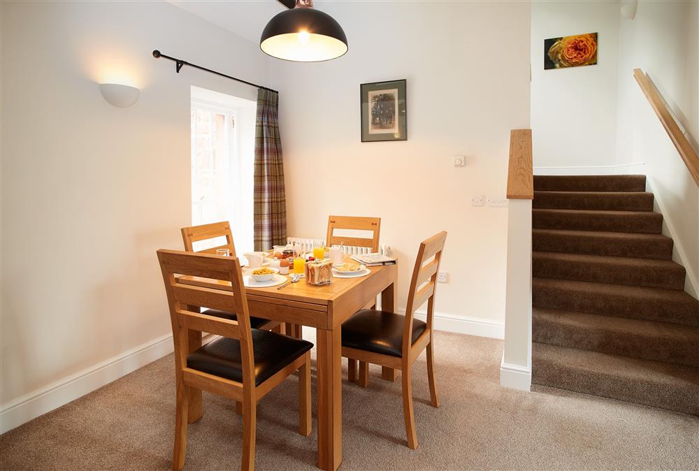 Dining area with seating for four guests and stairs up to the bedroom at Engineer Apartment, Netherby Hall, Longtown