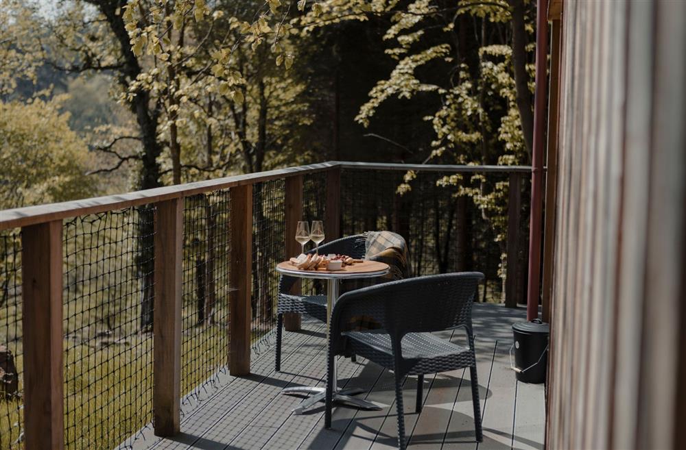 Two chairs and a table on the balcony overlooking the countryside