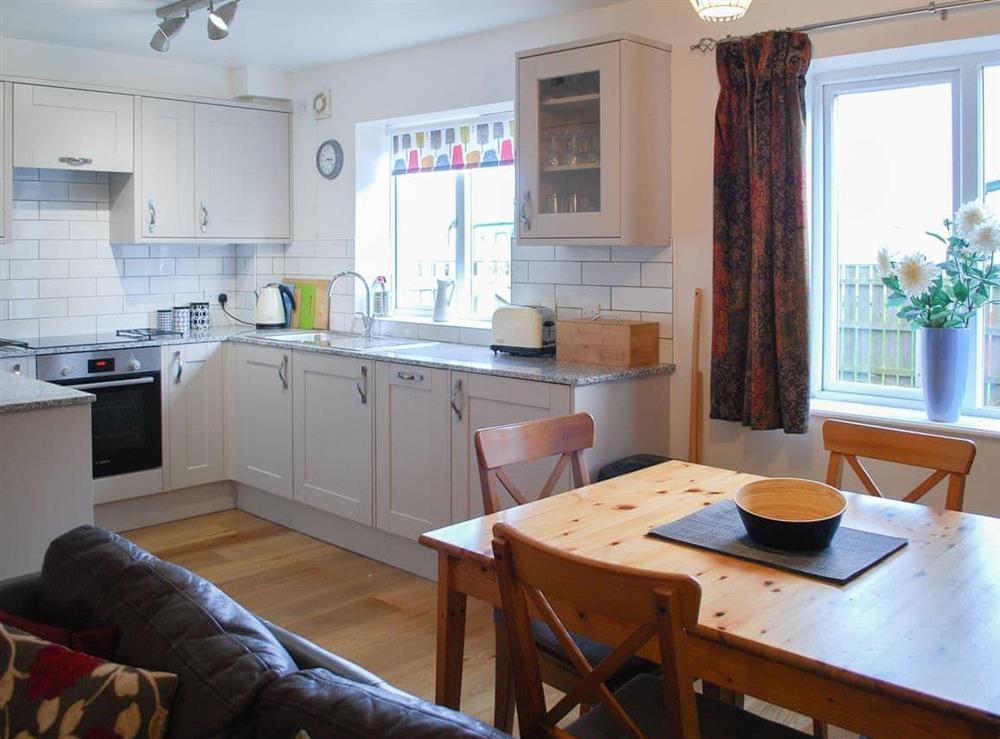 Delightful dining area and adjacent kitchen and living areas at Erskine Cottage in Seahouses, Northumberland