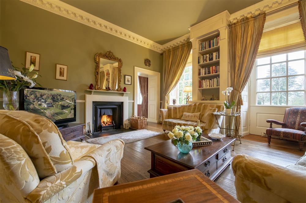 The sitting room with views of the surrounding grounds and an open fire at Eslington East Wing, Alnwick