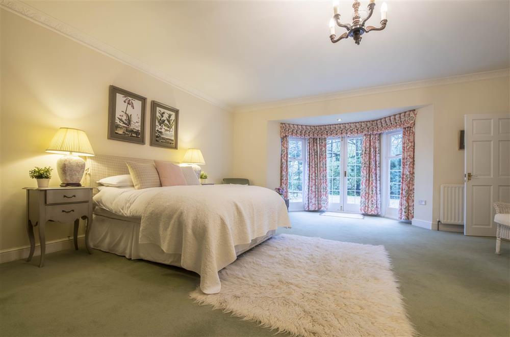 Expansive bedroom one with beautiful furnishings and patio doors with an accessible ramp at Eslington Lodge, Alnwick