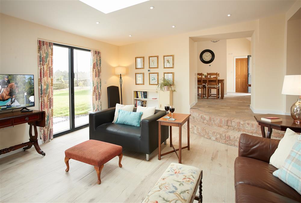 Evenwood Byre, Shropshire: Sitting room with bi-fold doors leading to the West facing lawn