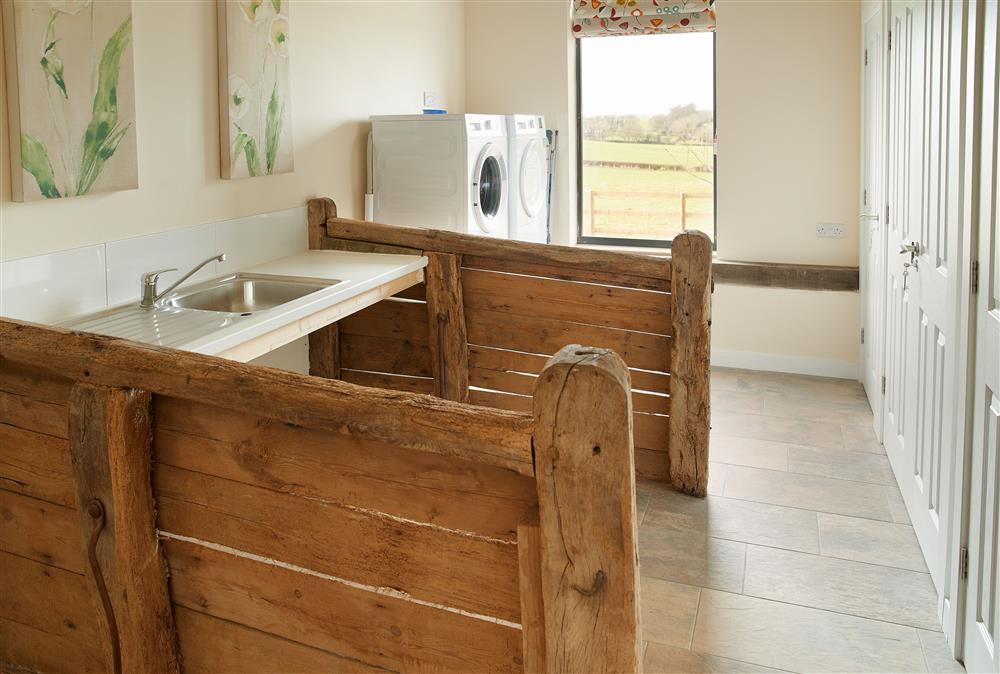 Evenwood Granary, Shropshire: Utility room with original wooden stalls and brick trough
