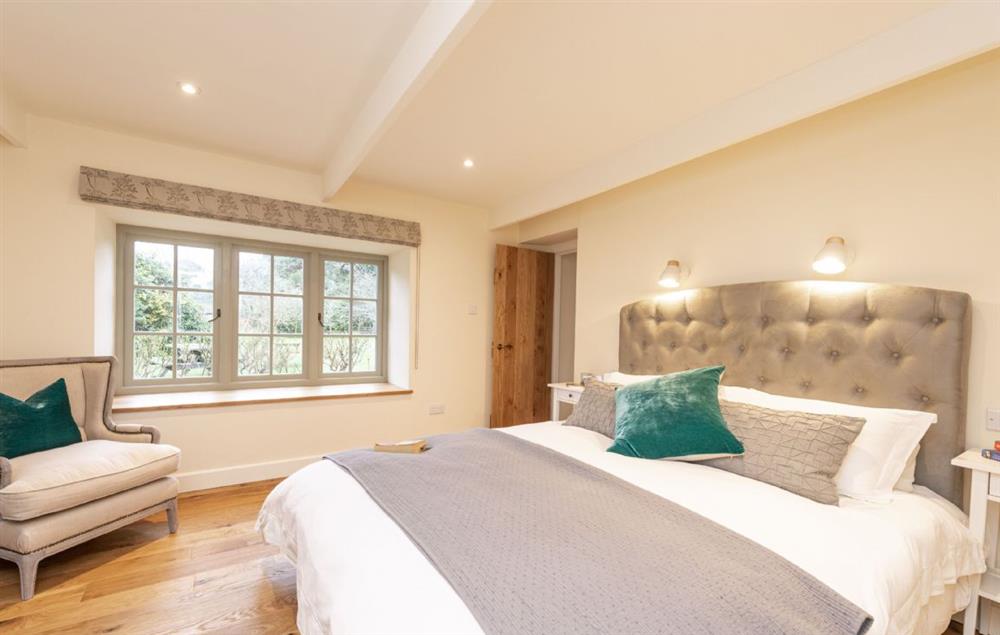 Bedroom with 5’ king-size bed, dressing room and en-suite at Evergreen, Bransgore