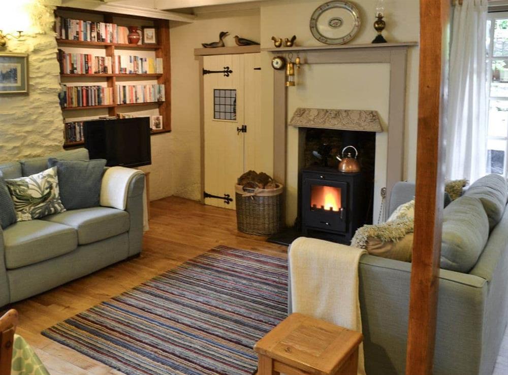Living room with dining area & wood burner at Fairmaiden in Polruan-by-Fowey, Cornwall., Great Britain