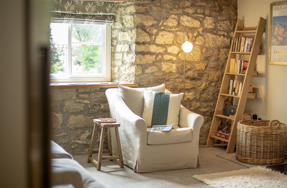 Sitting room with exposed stonework, beams and cosy seating