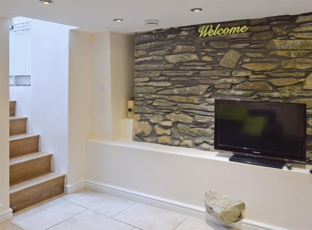 TV lounge with exposed stone feature wall at Falcon Crag** in Keswick, Cumbria