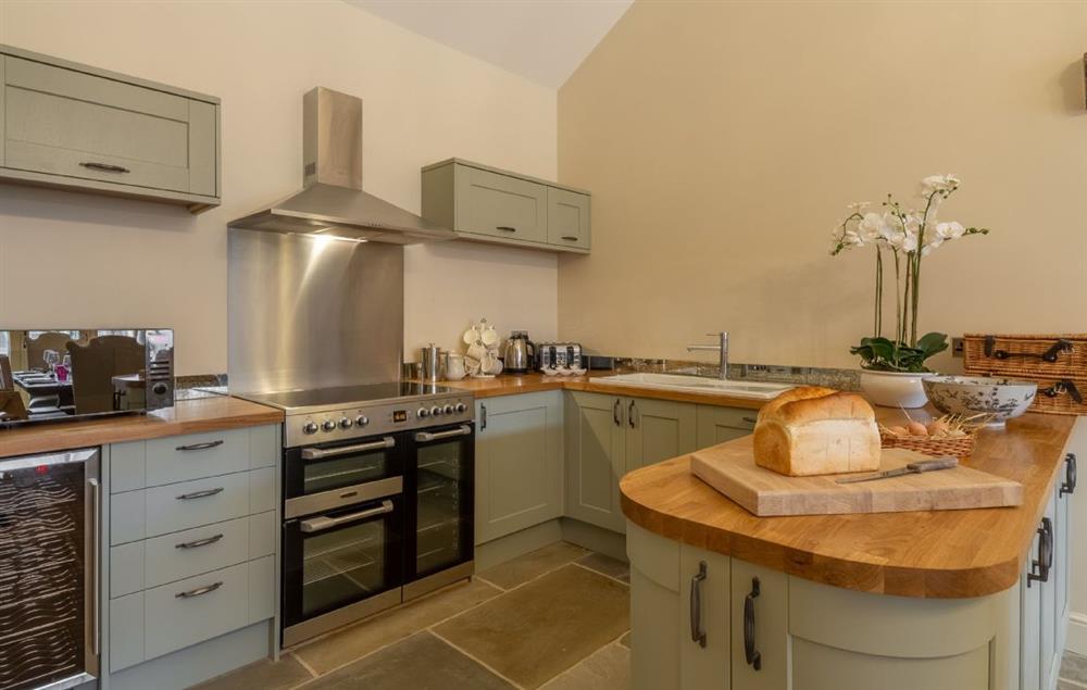 Open plan fully equipped kitchen, snug and dining table seating seven guests at Fallow Folly, Little Massingham