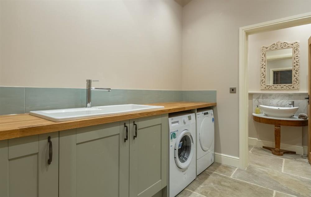 Utility room with sink, washing machine and tumble dryer