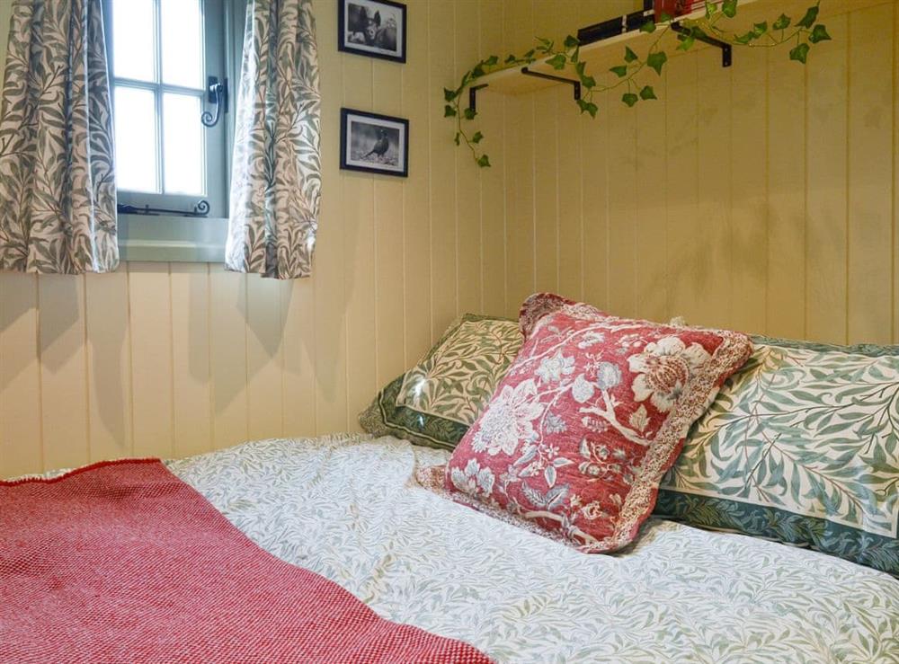 Comfortable double bed in sleeping area at Farmer Oaks Hut in Dippertown, near Tavistock, Devon