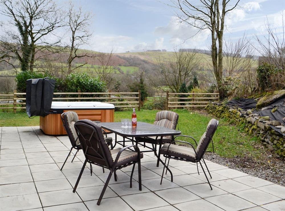 Paved patio with hot tub and outdoor furniture at Felin Goyan in Tregaron, near Lampeter, Cardigan/Ceredigion, Dyfed