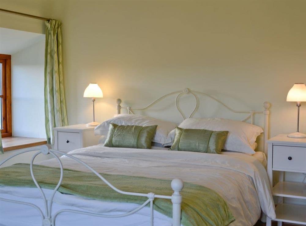 Pretty double bedroom which features french doors onto the balcony at Felin Hedd in Tregaron, near Aberystwyth, Dyfed