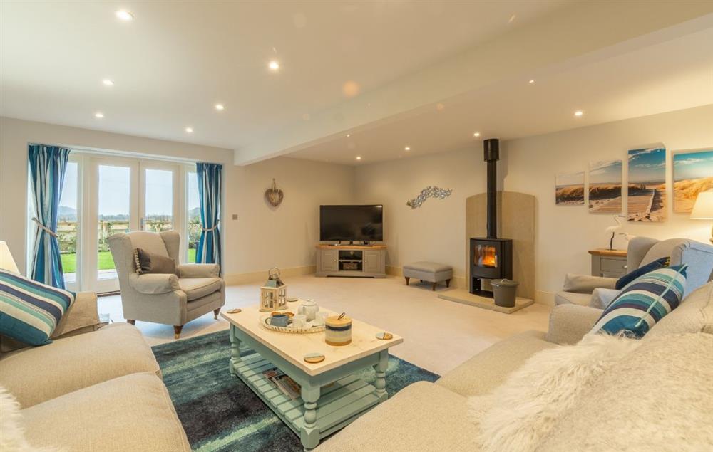 Ground floor: Spacious sitting room with comfortable sofas and a wood burning stove