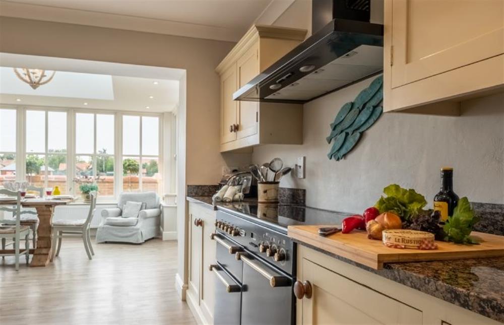 The kitchen leads through to the open-plan sitting area and garden room with dining area  at Field Piece Cottage, Burnham Market