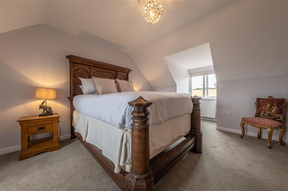 Bedroom one on the second floor with a 5’ king-size antique oak bed at Field View, Sedgeford