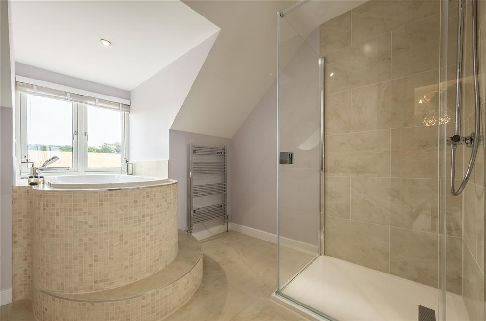 Bedroom one’s en-suite with a free-standing bath and walk-in shower at Field View, Sedgeford