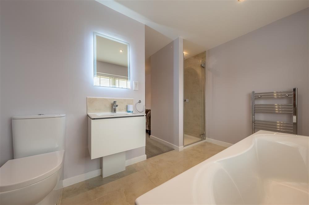 En-suite to bedroom two with a bath and walk-in shower at Field View, Sedgeford