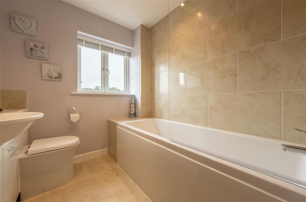 Family bathroom on the first floor with a bath with electric shower over at Field View, Sedgeford