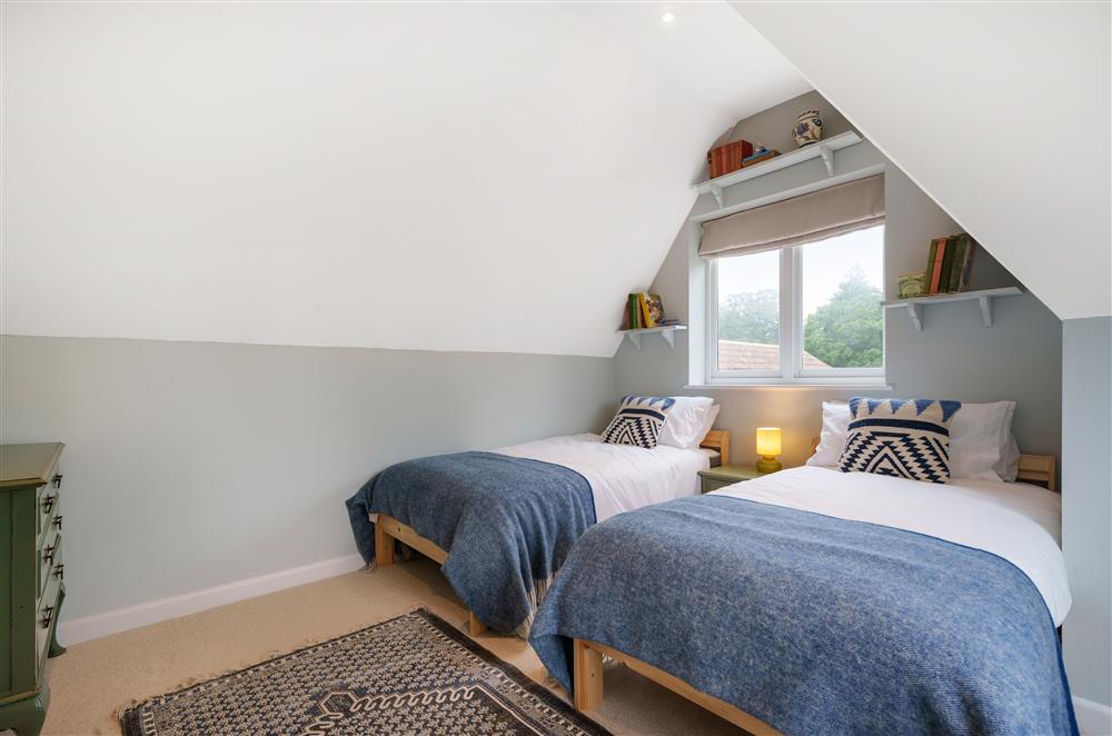 Bedroom two, with 3’ twin beds and feature bookshelves at Fig and Bay Cottage, Axminster